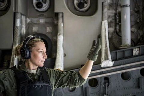 An airman gestures aboard an aircraft. 