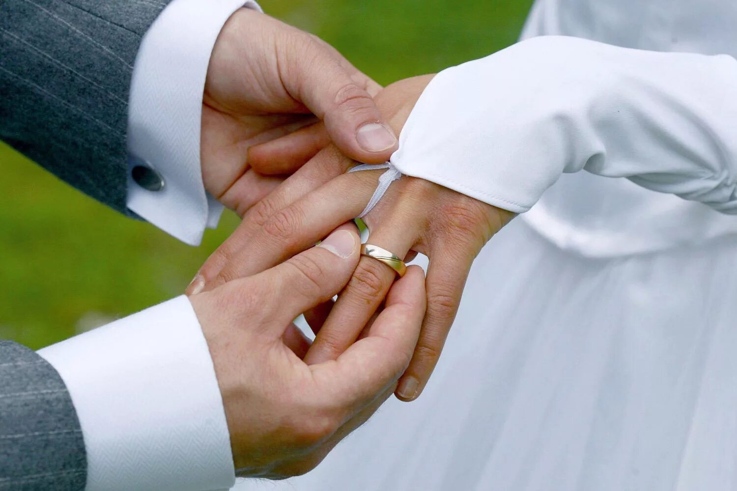 Кольцо замужества. Свадьба руки с кольцами. Молодожены одевают кольца. Свадьба надевают кольца. Обмен обручальными кольцами.