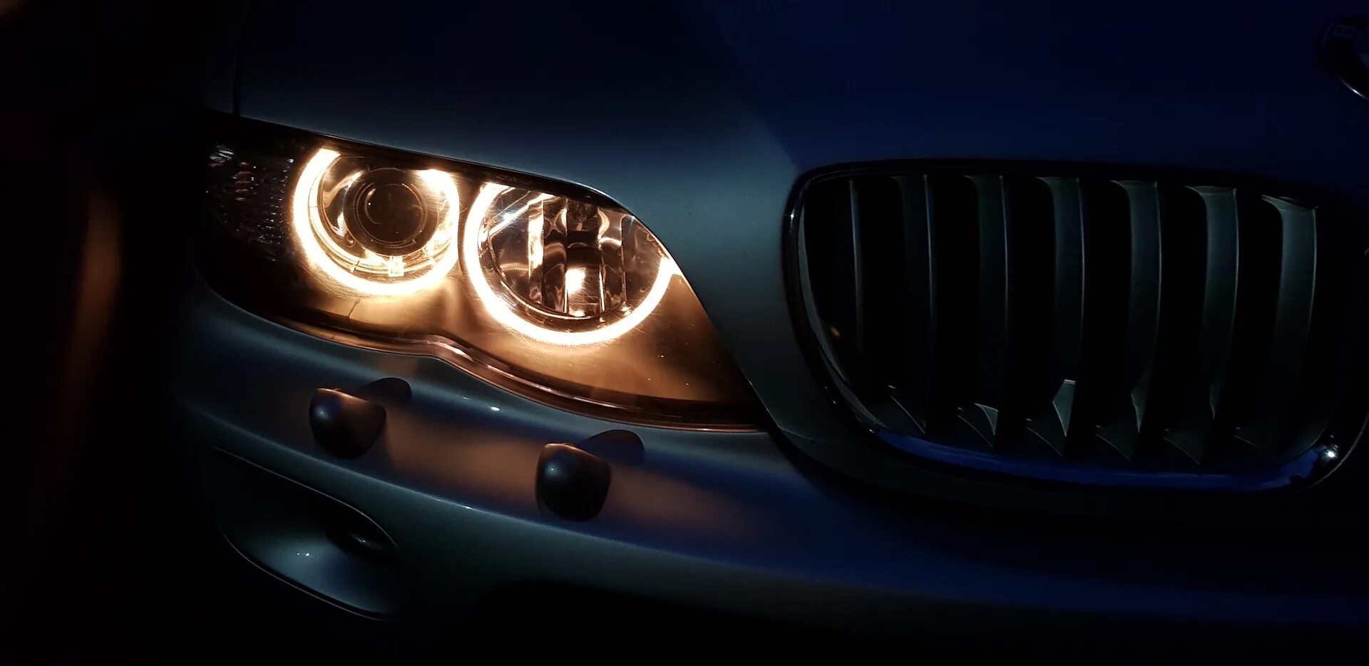 Улучшенные фары. BMW e53 глазки. БМВ x5 e53 фары в темноте. BMW x5 e53 спереди фары. BMW x5 e53 желтые глазки.