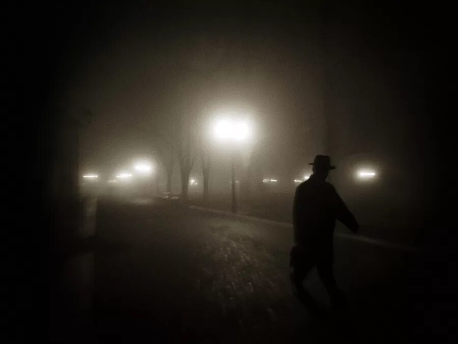 Идущий в темноте. Человек на ночной дороге. Человек на дороге ночью. Уличный фонарь ночью. Человек в темноте на улице.