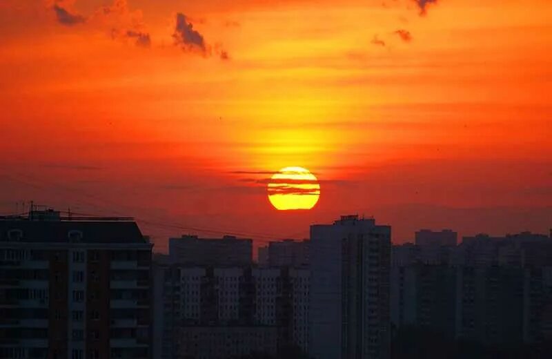 Вечерний закат в городе. Закат из окна многоэтажки. Закат над городом. Город солнца.