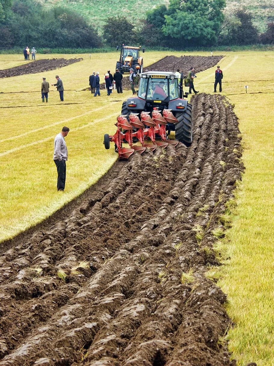 Сельское хозяйство. Трактор на пашне. Распашка земель. Сельскохозяйственная техника для вспахивания почвы.