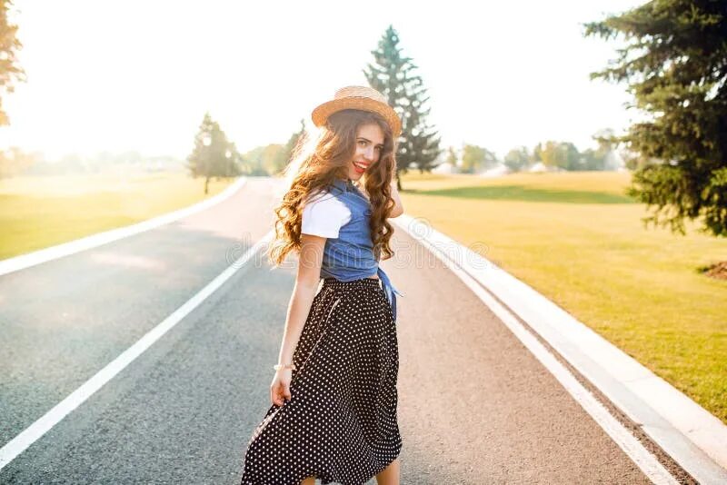 She s wearing her skirt. She is Walking. She's wearing. She is wearing Tas. She is wearing a Top.