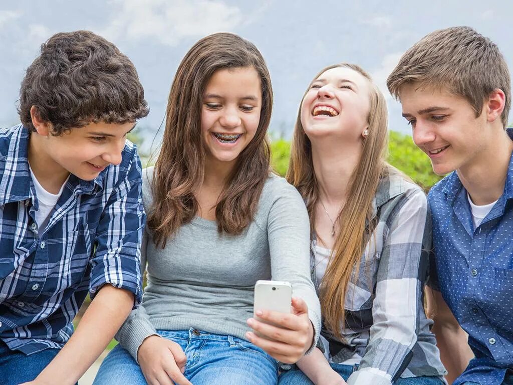 школьники в школе. Teenagers have their. юношеский возраст. взаимоотношения друзей. подросток с телефоном.