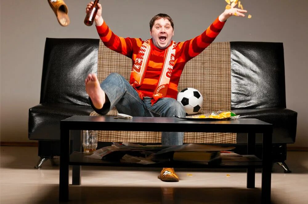 Телевизор смотрим футбол. Футбольный болельщик на диване. Футбольный болельщик у телевизора. Болельщики перед телевизором. Футбольные фанаты перед телевизором.