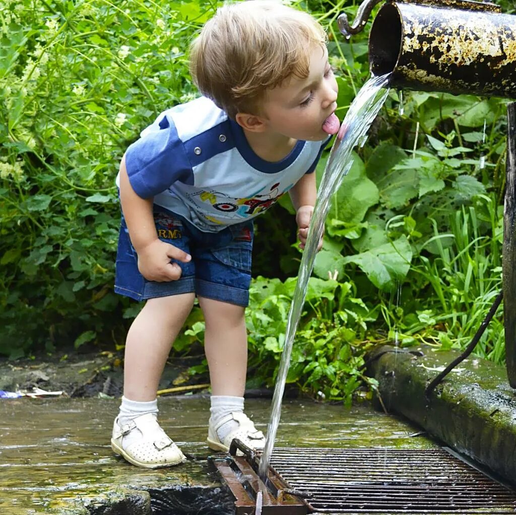 Мужик в ручье. Дети воды. Ребенок пьет воду из родника. Пьет воду из ручья. Пить воду из водоемов.