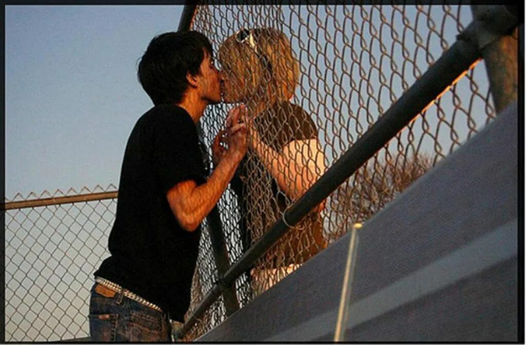 Поцелуй через забор. Любовь между парнем и девушкой. Любовь за решеткой. Влюбленные у забора.