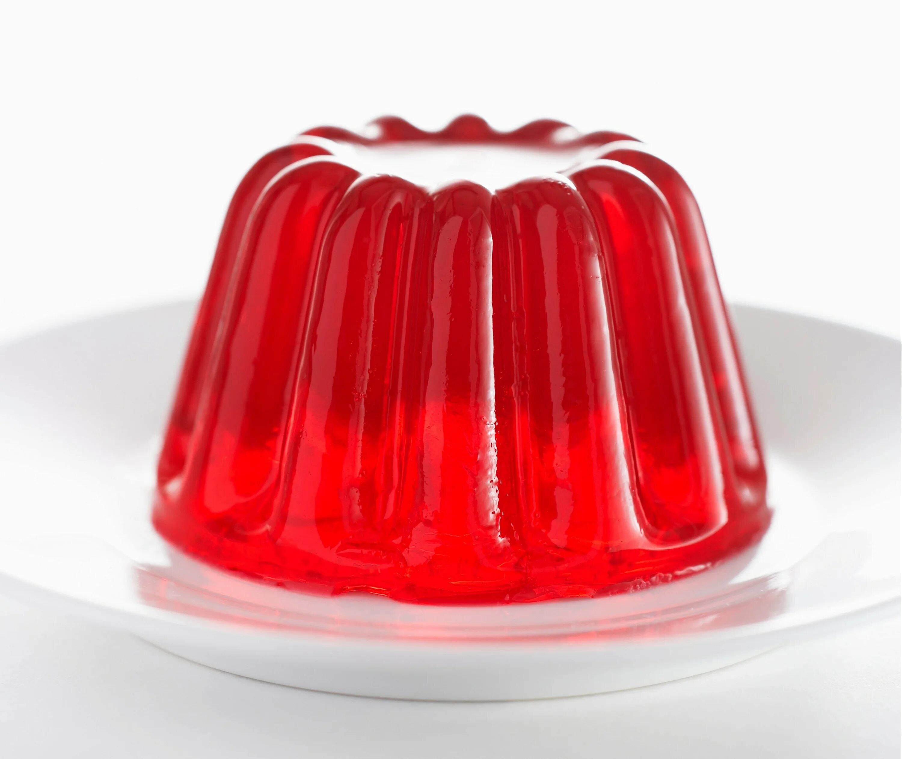 Лимонное желе. Съедобное желе. Желе с молоком. Желе на тарелке. Желе на белом фоне.