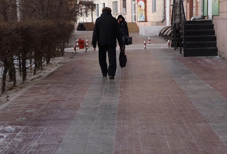 Жители города жалуются. Скользкая плитка. Нескользкая плитка у здания народного Хурала. Скользкая плитка в парке Швейцария. Человек укладывает плитку на улице.