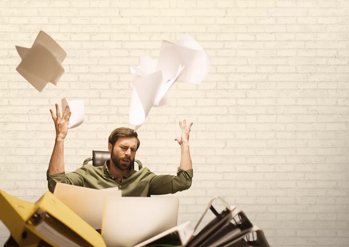 Человек выбрасывает бумагу. Бросает листы бумаги. Человек подкидывает бумаги. Выброшенная бумага.
