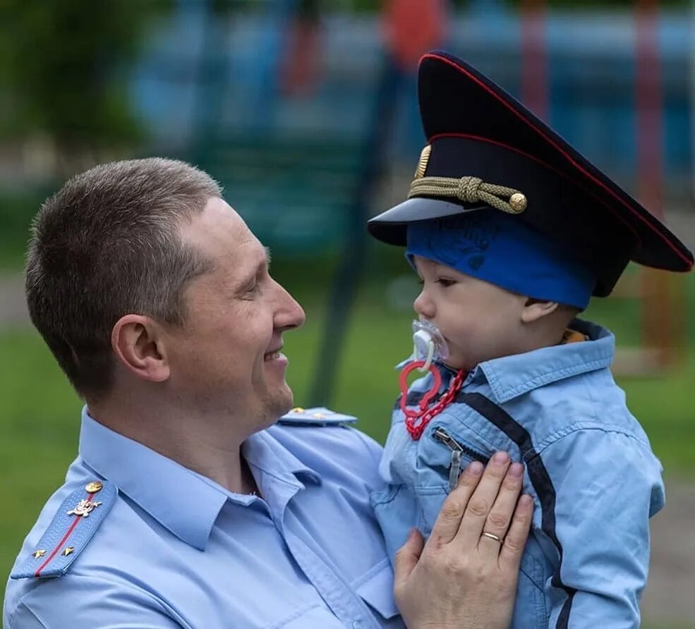 Сотрудник полиции улыбается. Семейная фотосессия полицейских. Семейная фотосессия в форме сотрудника полиции. Полиция России улыбается ребенку.