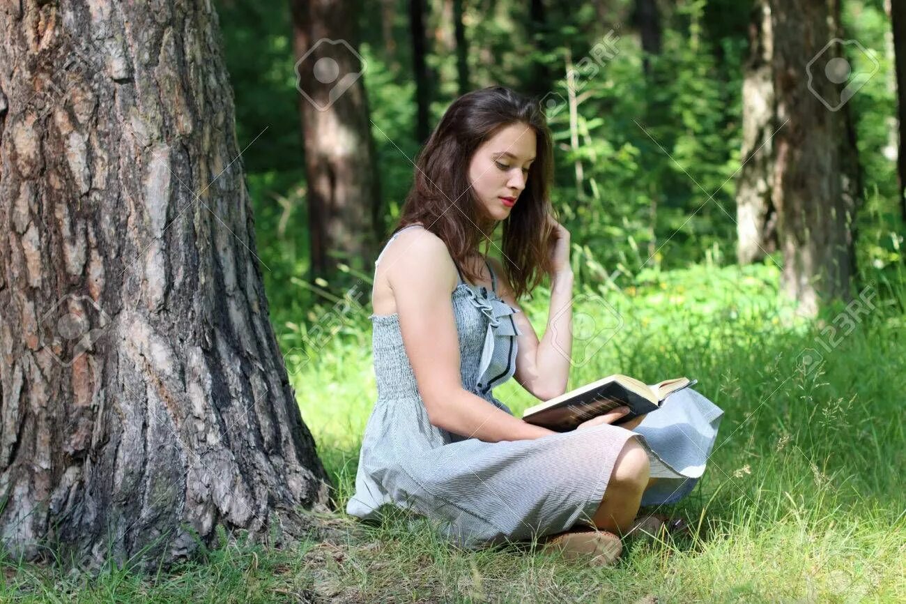 Девушка с книжкой под деревом. Женщина сидит под деревом. Девушка сидит под деревом. Фотосессия в деревьях с книгой. Сидящая женщина с книгой