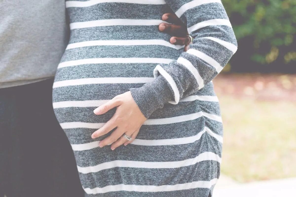 Обнимает беременную. Беременные. Беременность свитер. Красивый свитер для беременных.