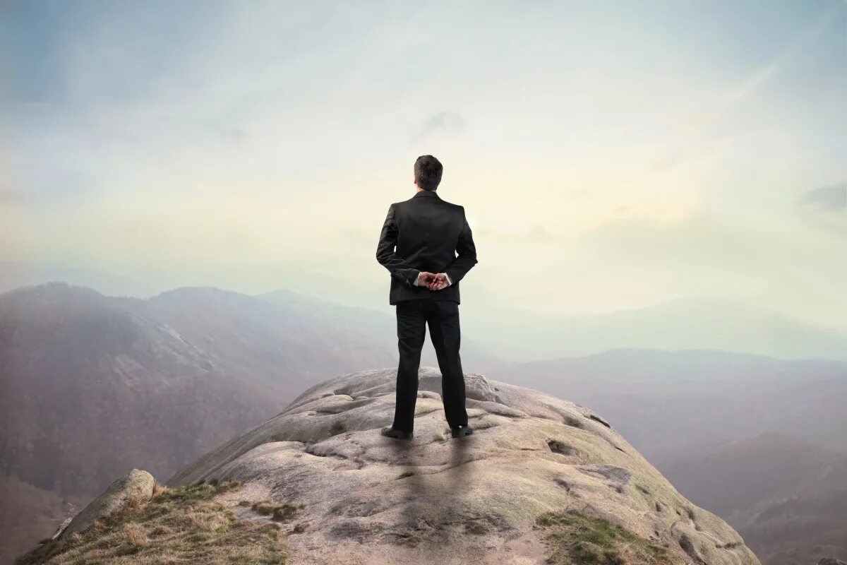 счастливое будущее. фото человека глядящего в будущее. человек вглядывается в даль. человек на вершине горы. человек с биноклем ищет.