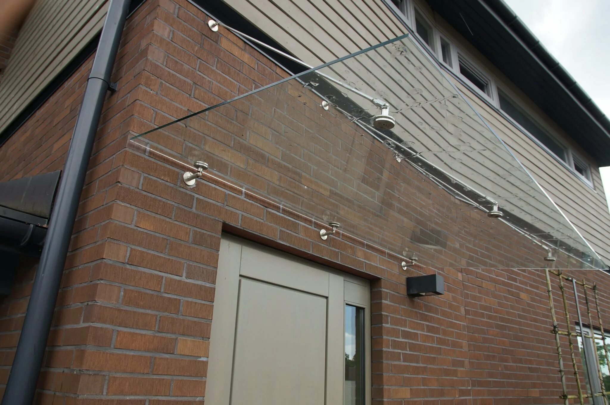 Кабель по фасаду здания. Стеклянный козырек в подъезд. Прокладка кабеля в трубе по фасаду. Кабель по фасаду здания. Крепление кабеля по фасаду здания.