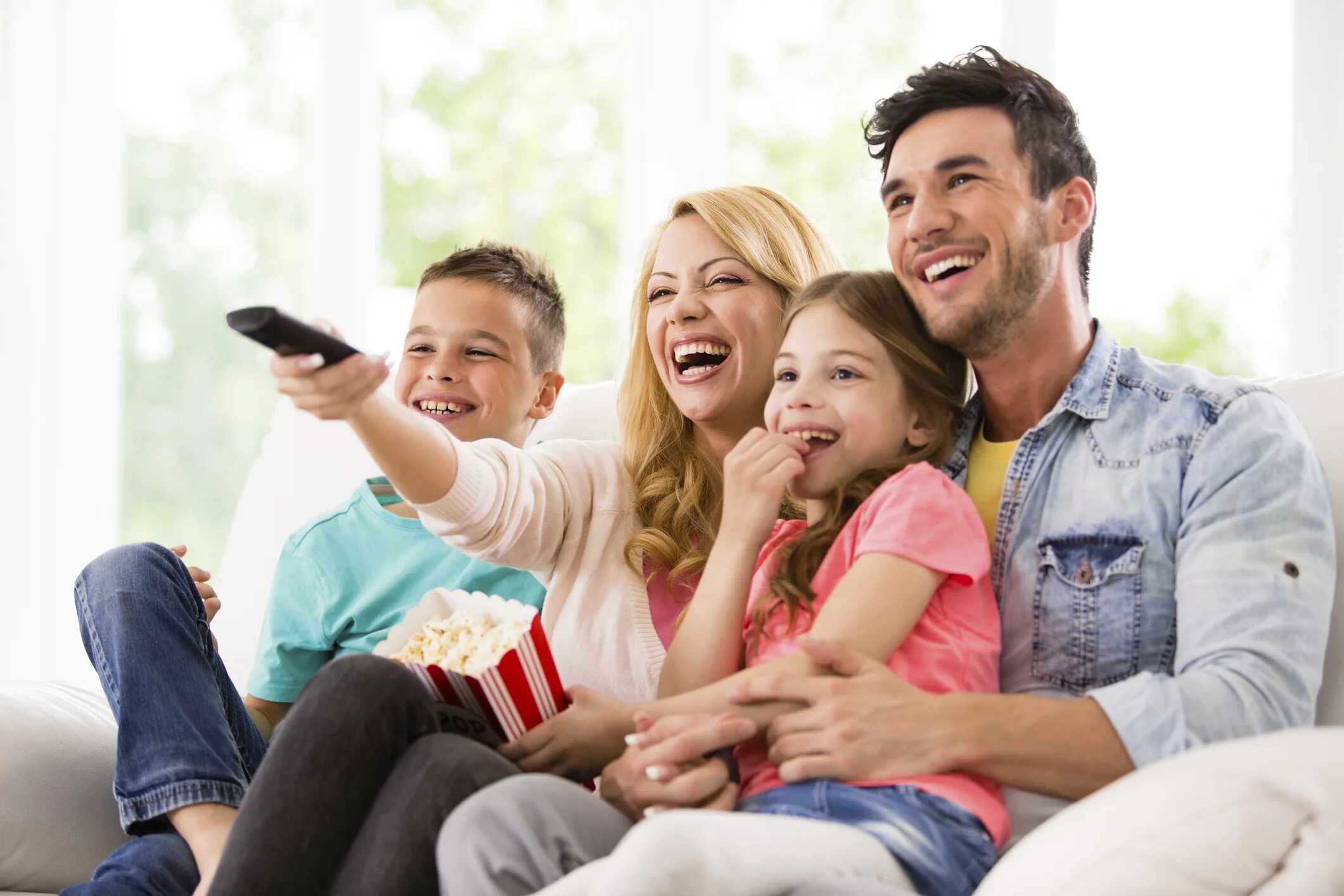 Вместе смотрят телевизор. Семья у телевизора. Счастливая семья у телевизора. Родители и дети. Счастливый ребенок с родителями.