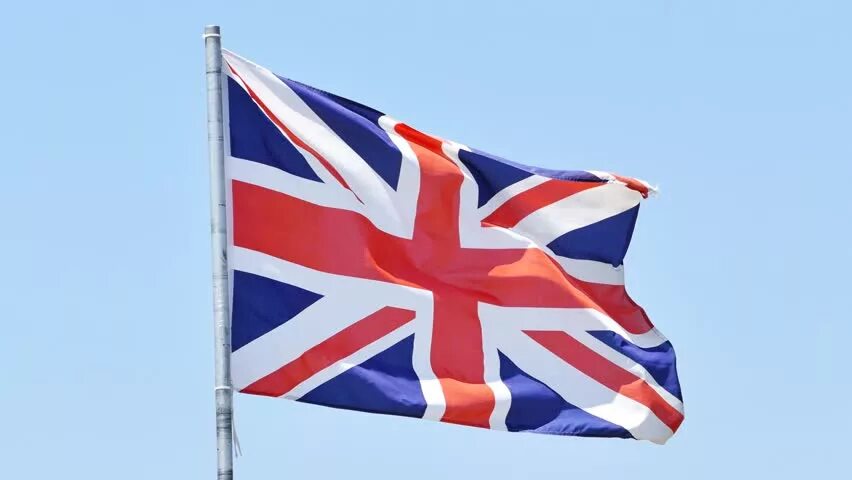 Флаг Великобритании. Британский флаг развевается на ветру. Развевающийся флаг Великобритании. Флаг Великобритании фото. Почему в британии приспущены флаги