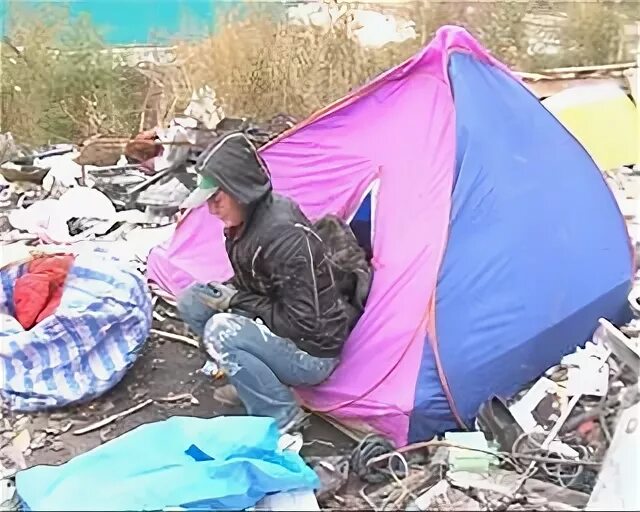 Бомжи в палатке на природе. Бомжи в палатке возле здания.