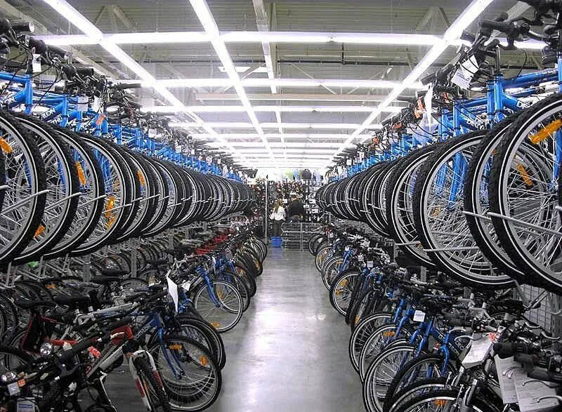 На складе велосипедов среди них женских. Склад велосипедов. Завод велосипедов. Велосипеды в ассортименте. Оптовый склад велосипедов.
