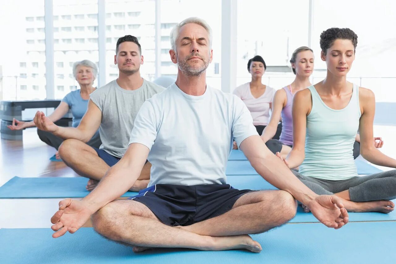 Человек в позе лотоса. Йога групповые занятия. Человек в медитации. Йога много людей.