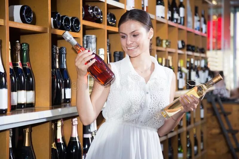 Помогает выбирать вино. Женщина выбирает вино. Выбор вина в магазине. Человек выбирает вино. Вино на выбор.