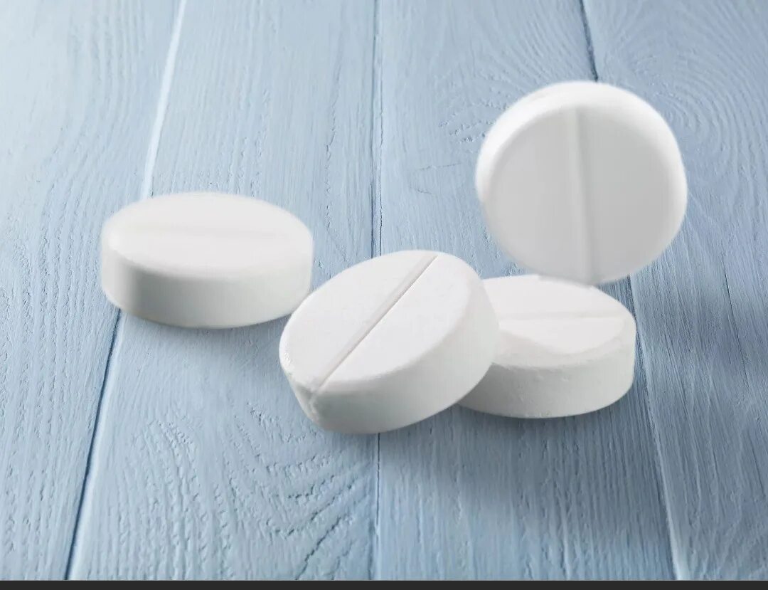 Первая таблетка. Белые таблетки. Таблетка белая круглая. Круглые плоскоцилиндрические таблетки. Таблетки на белом столе.
