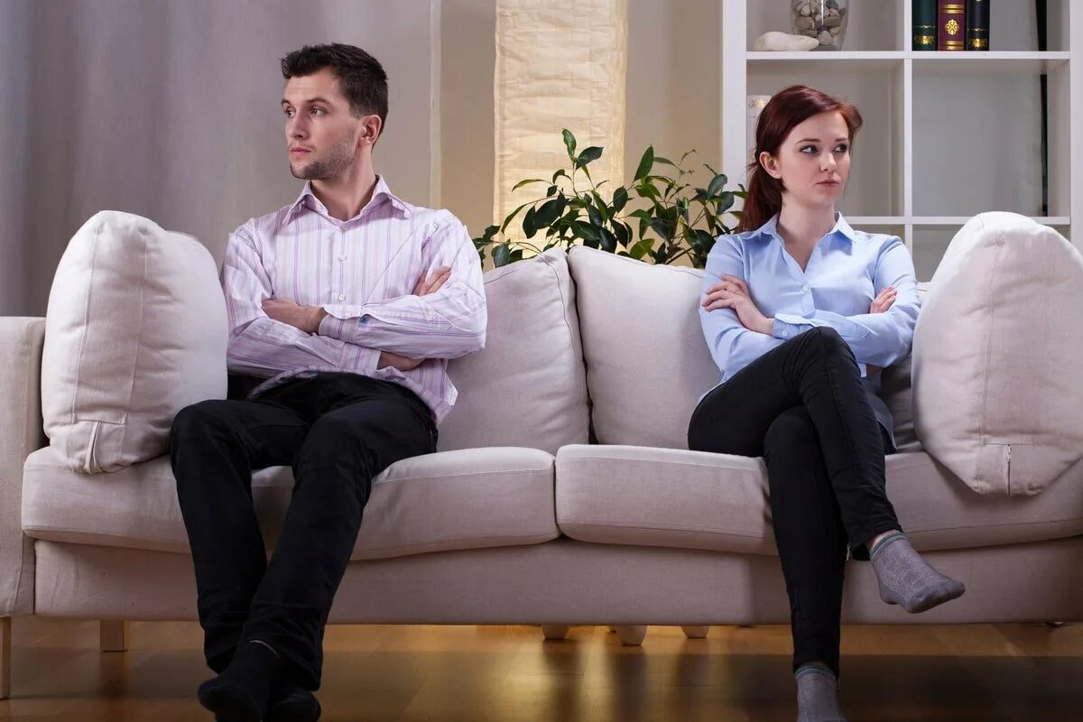 Развод супругов. Мужчина и женщина на диване. Кризис отношений мужчины и женщины. Разлад в семье. Кризис семьи.