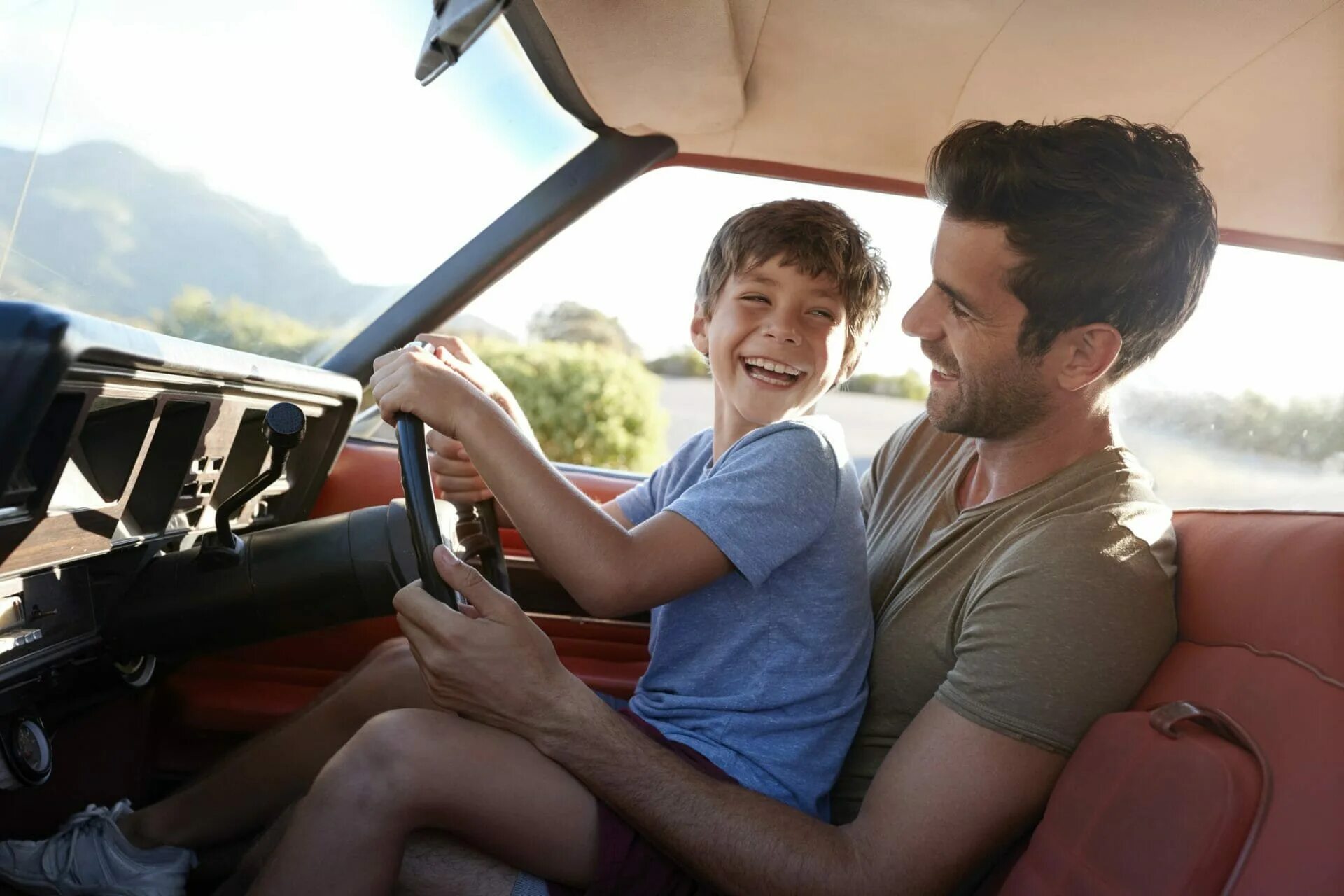 Отец и сын за рулем. Папа с сыном за рулем. Папа и ребенок в машине. Папа учит водить машину.