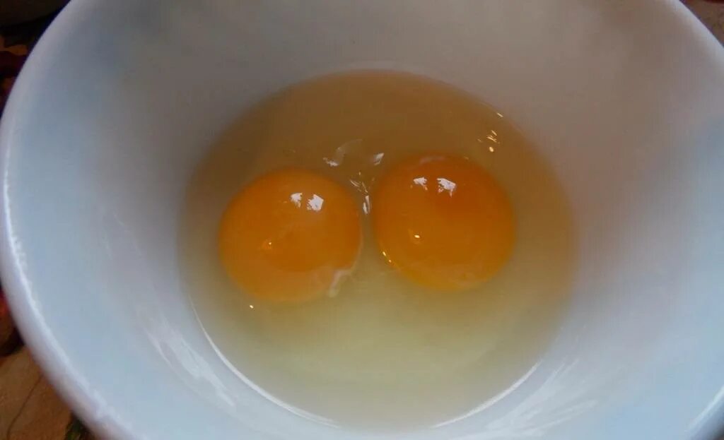 Два желтка примета. Двухжелтковые яйца. Яйцо с двумя желтками. Двойной желток в яйце. Переваренные яйца.