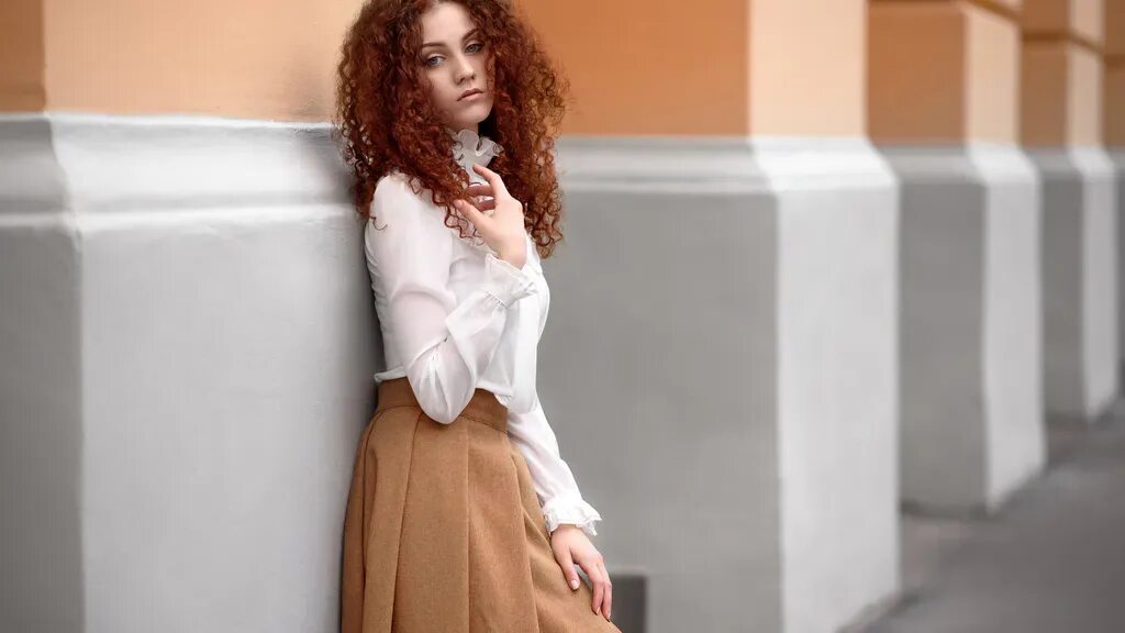 Кудрявая рыжая девушка с длинными ножками 