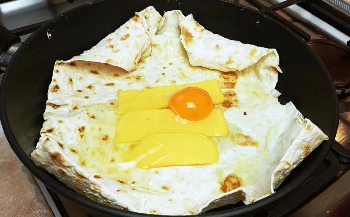Лаваш с сыром и яйцом на сковороде. Завтрак из лаваша. завтрак из лаваша на сковороде. завтрак из лаваша и яиц. лаваш с яйцом на сковороде на завтрак.