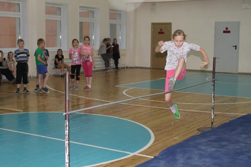 Прыжок в высоту перешагиванием. Прыжок в высоту с разбега. Прыжки в высоту с разбега в школе. Прыжки в высоту школьники. Прыжки в высоту в школе.