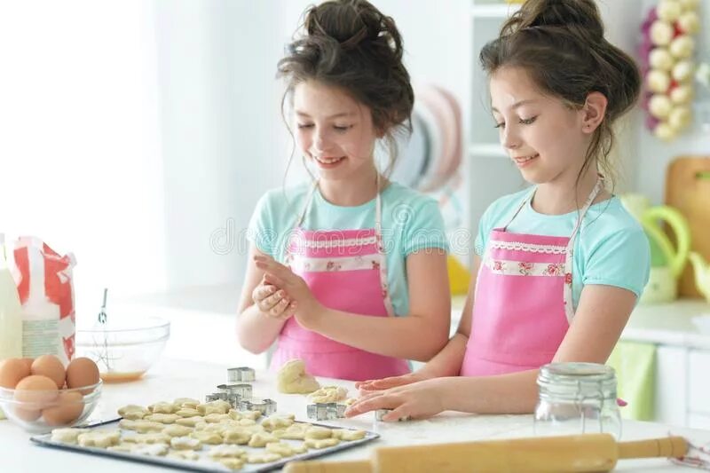 A sister Cooks. Two sisters Cooks. Two sisters Kitchen. Two girls Cook.