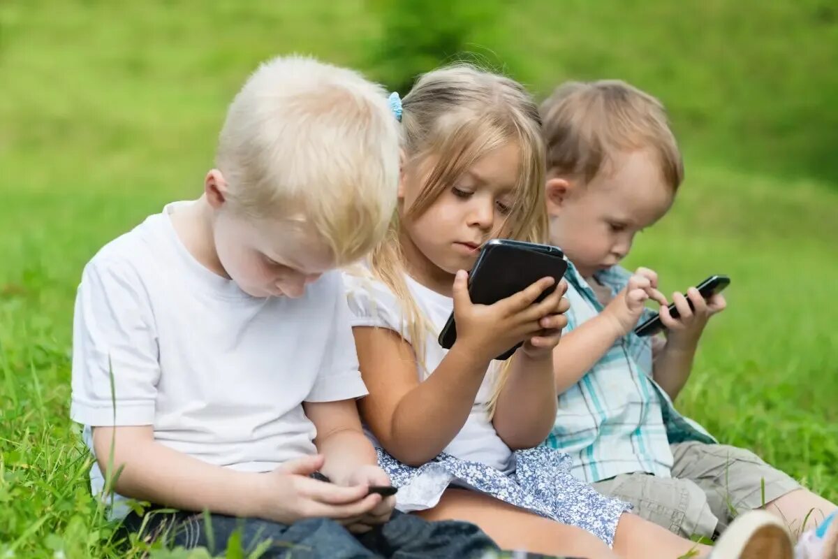 Малыши играют в телефон. Современные дети и гаджеты. Дети с мобильниками и планшетами. Ребенок со смартфоном. Общение детей.