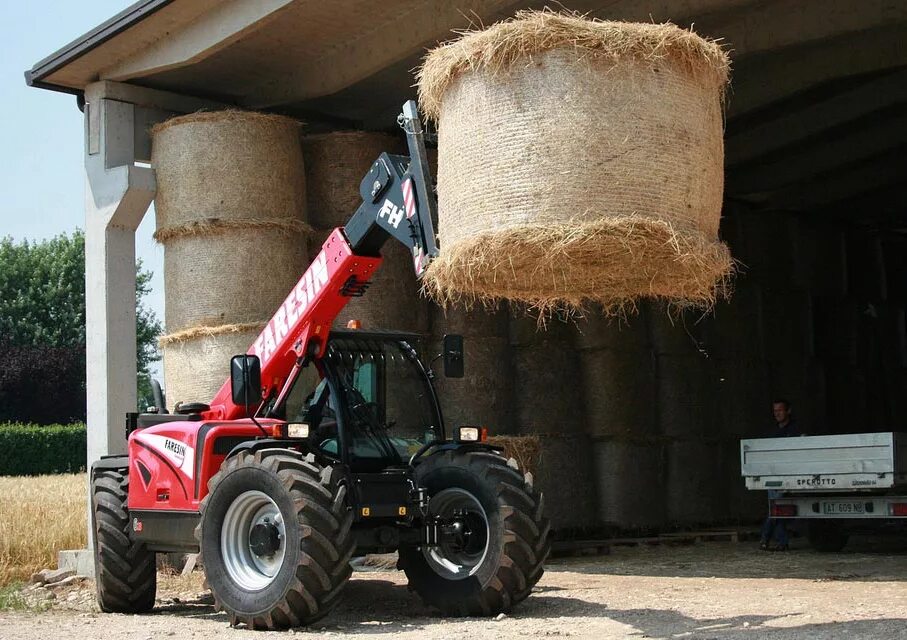 Погрузчики сена. Manitou погрузчик телескопический сено. Погрузчик Маниту с рулоном сена. Вилы для тюков телескопический погрузчик. Dieci погрузчик для тюков.