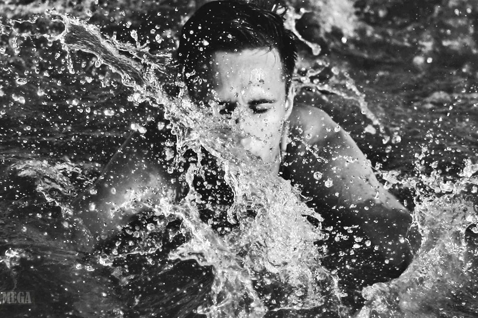 Красивый парень в воде. Мужчина в воде. Мужчина выныривает из воды. Брызги воды на лице. Вода и человек.