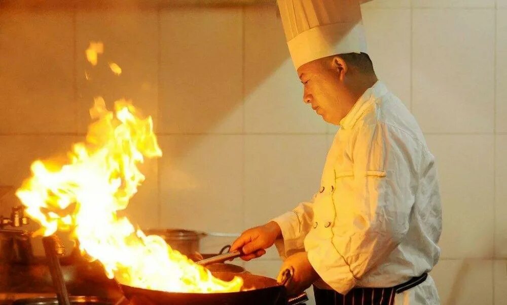 Повар китайской кухни. Повар жарит. Повар огонь. Повар готовит.
