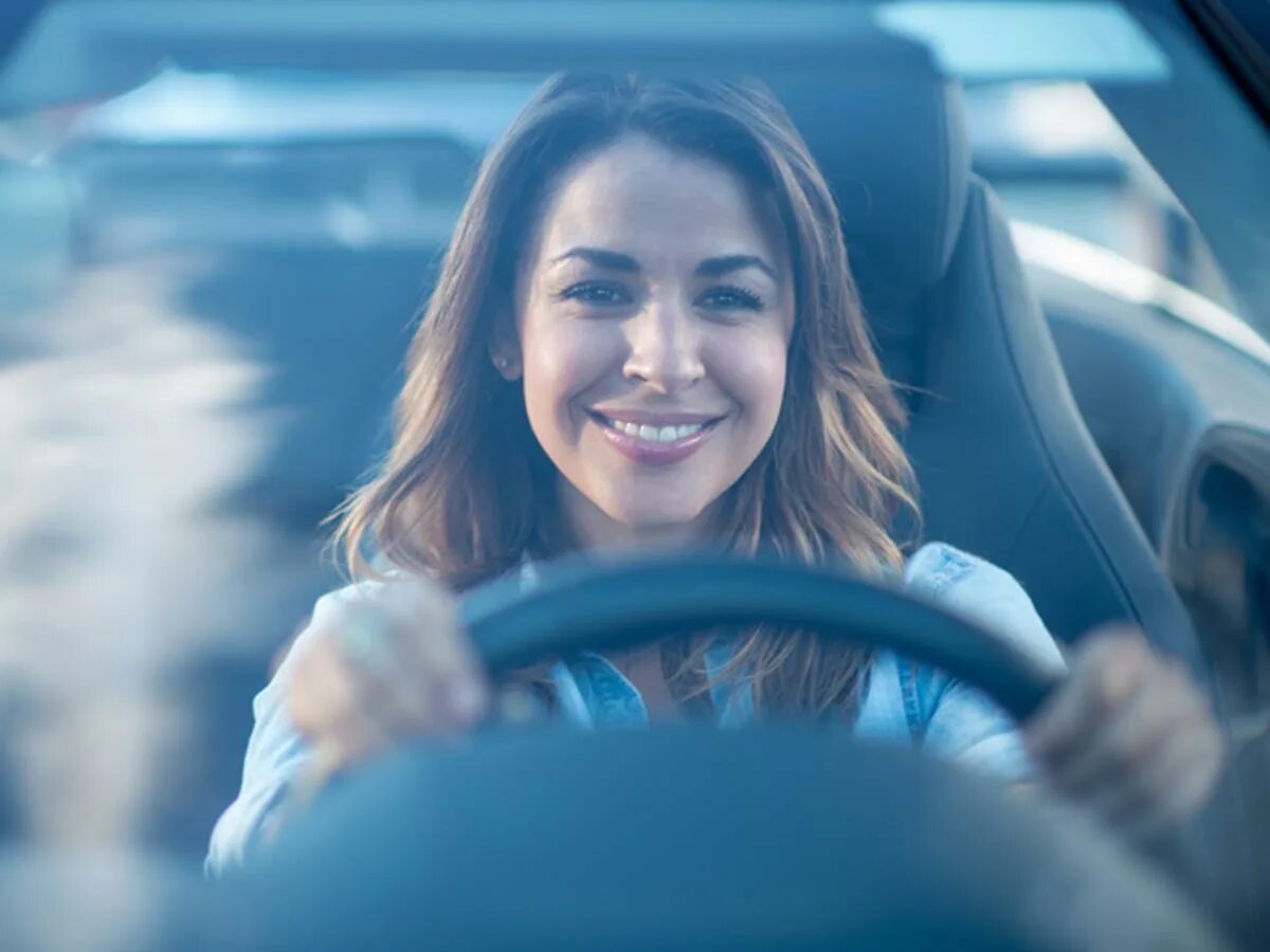She drive a car now. Девушка в машине улыбается. Счастливый водитель. Счастливые люди в машине. Счастливый человек за рулем.