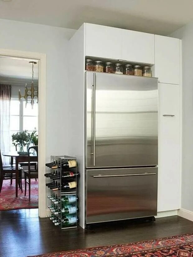 Как можно закрыть холодильник. Холодильник в кухонной нише. Холодильник в интерьере. Бутылочницы холодильники для кухни. Полка шкаф под холодильник.