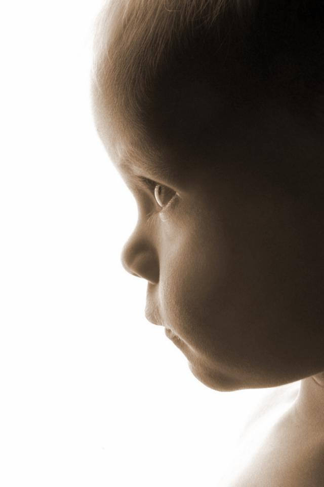 ребенок в профиль. ребенок улыбается в профиль. малыш на темном фоне. мальенькадевочкавпрофиль. профиль ребенка.