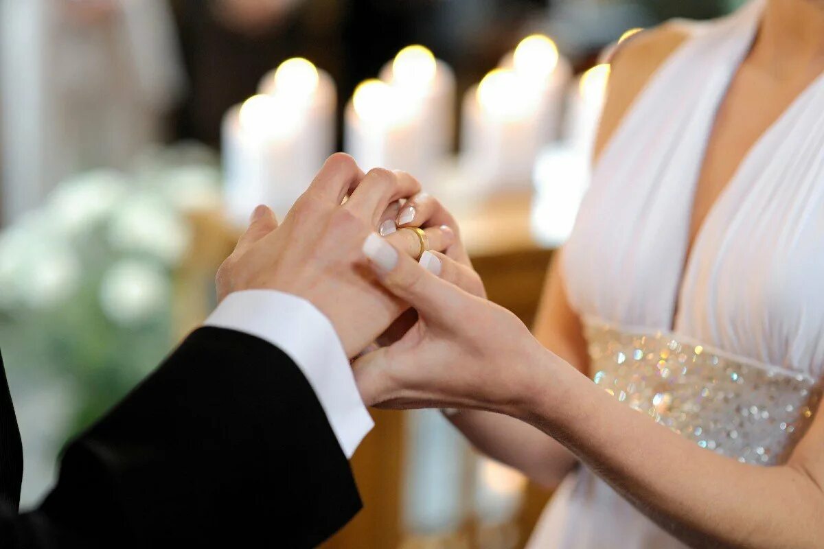 Свадебные кольца. Обручальные кольца на руках. Одевает кольцо. Свадьба руки с кольцами.