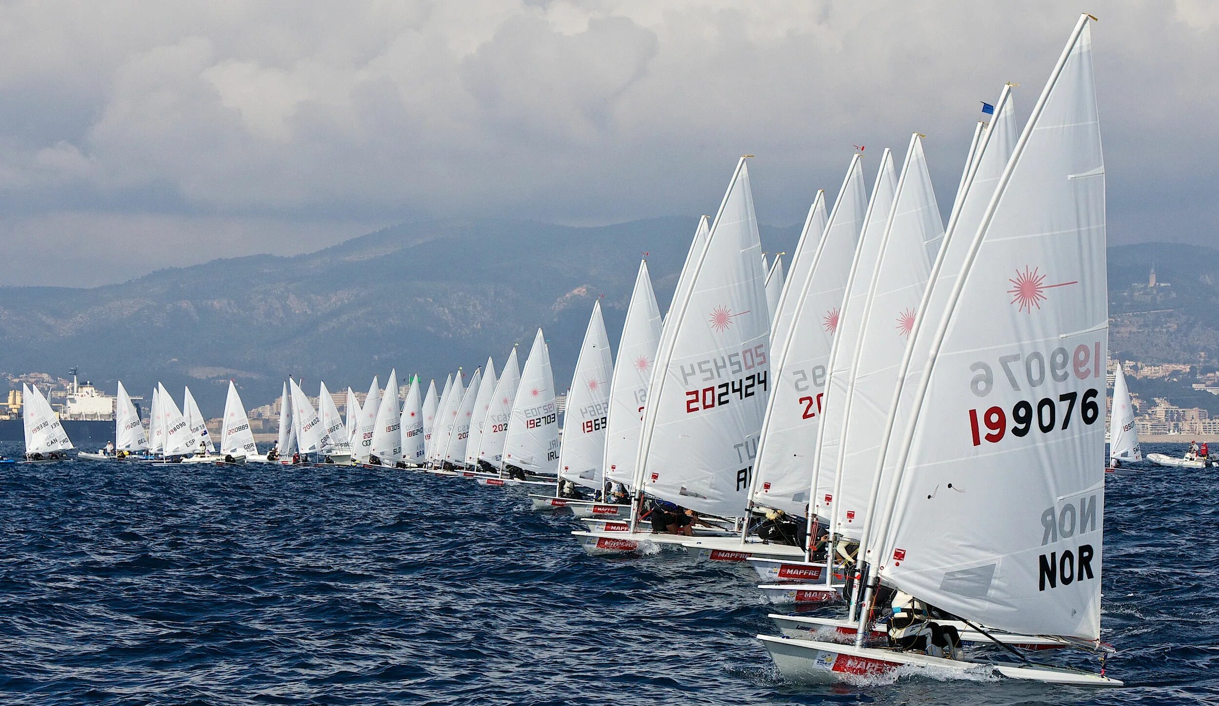 Яхтенная регата. Sailing страна. Яхта парусная регата. Яхта с разноцветными парусами. Виды sports sailing надпись.