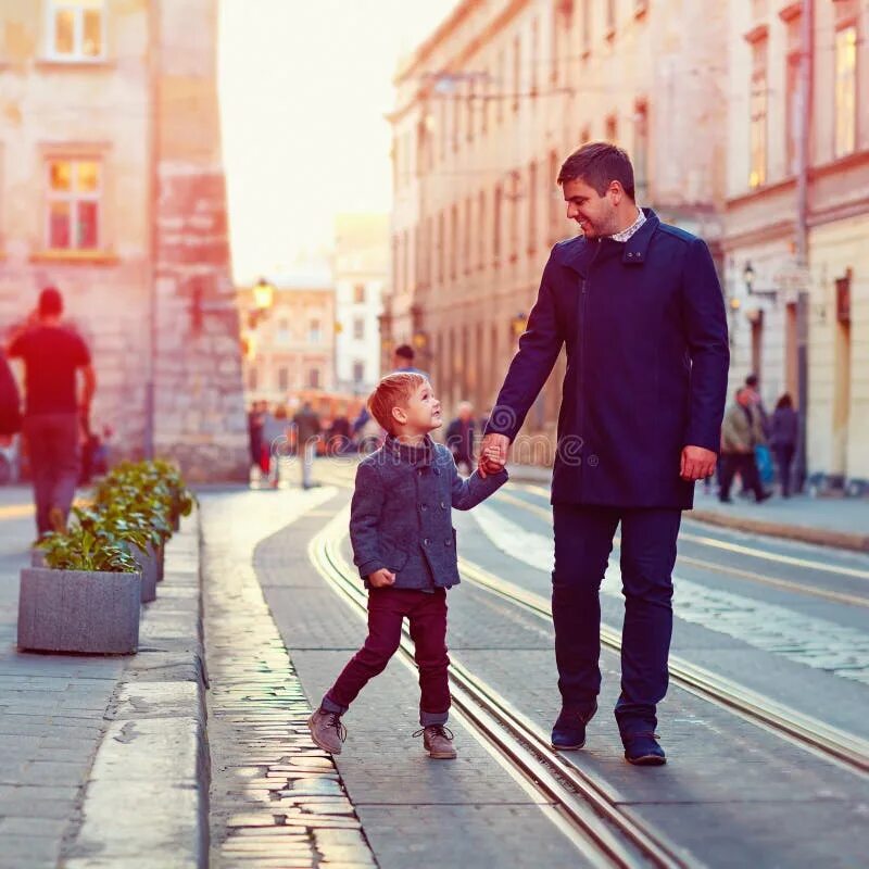 City fathers. Папа с сыном идут. Фотосессия отец и сын прогулка в городе. Отец с сыном гуляют. Мама с сыном идут по улице.