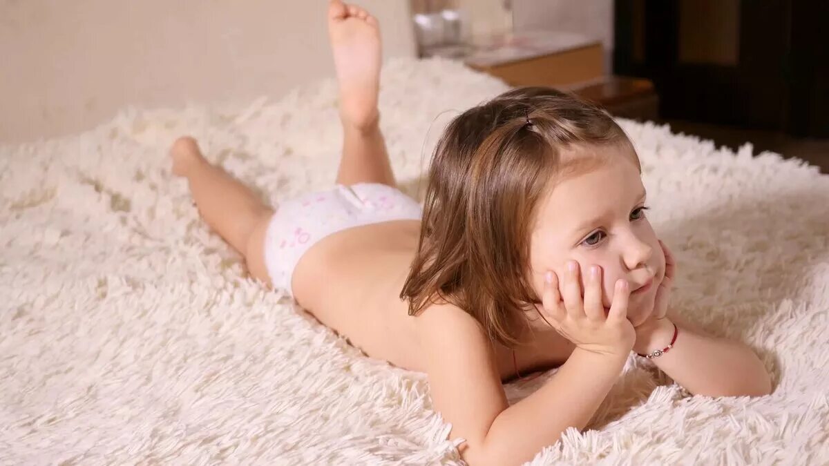 Little girl models young 8 12. The child sat on the Bed. Spread.