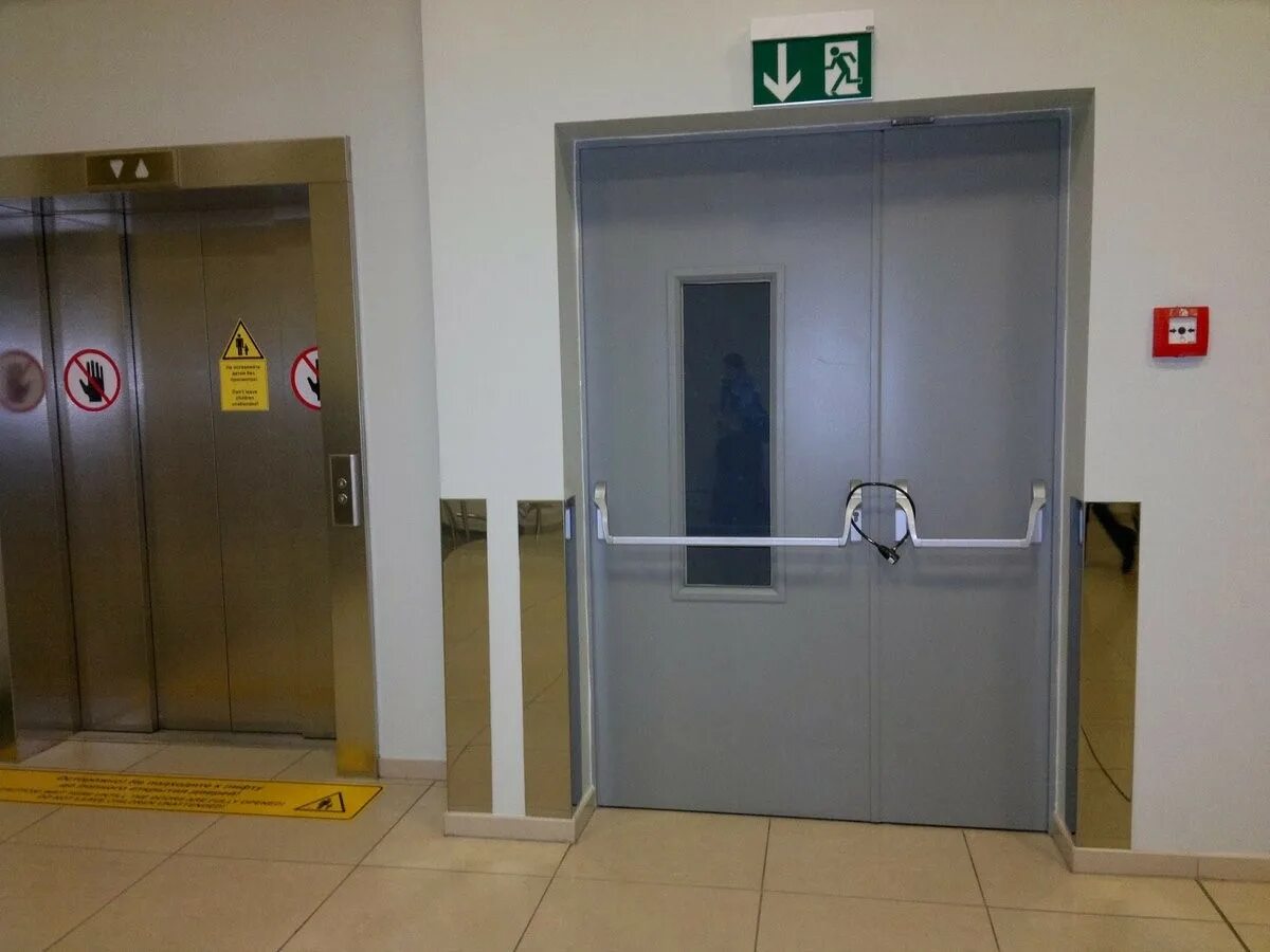 Им нужно открыть дверь. Двери в лифтовой Холл противопожарные. Эвакуационная дверь. Противопожарные эвакуационные двери. Лифтовые противопожарные двери.