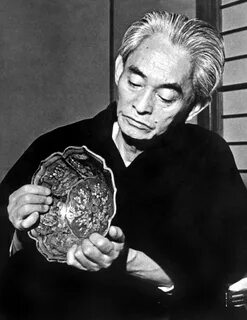Кавабата Ясунари осматривает предмет из коллекции в своём доме в Дзуси, пре...