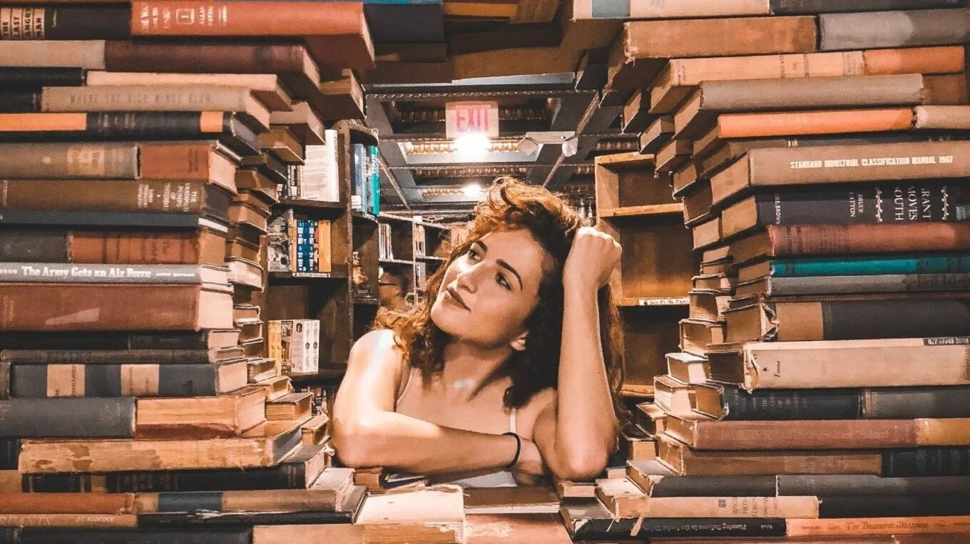 Много книг. День книголюбов. Девушка с книгой. Чтение в странных местах. Книжное кафе.