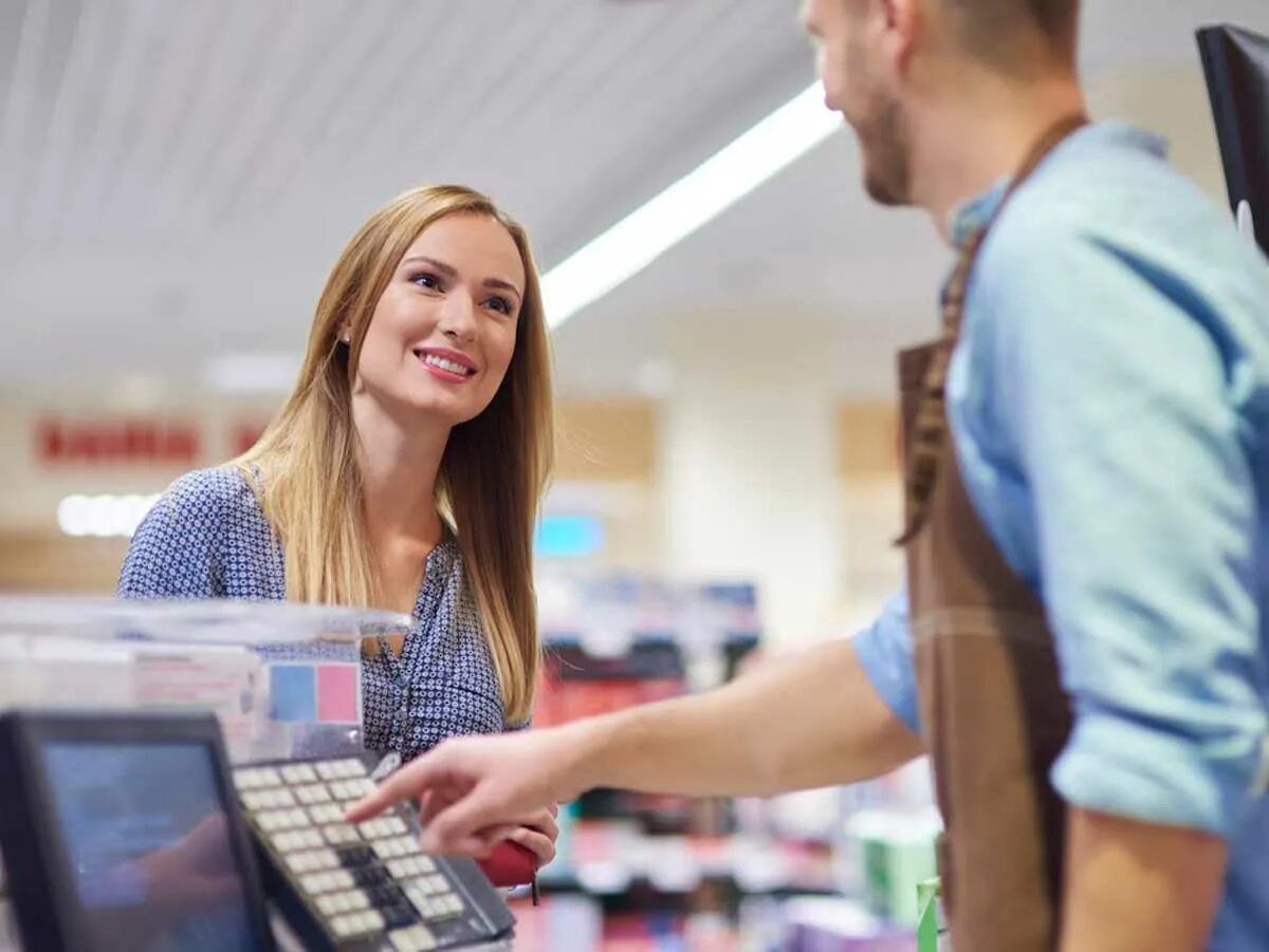 1с продавец. Продавец и покупатель. девушка возле кассы. человек возле кассы. кассир и покупатель.