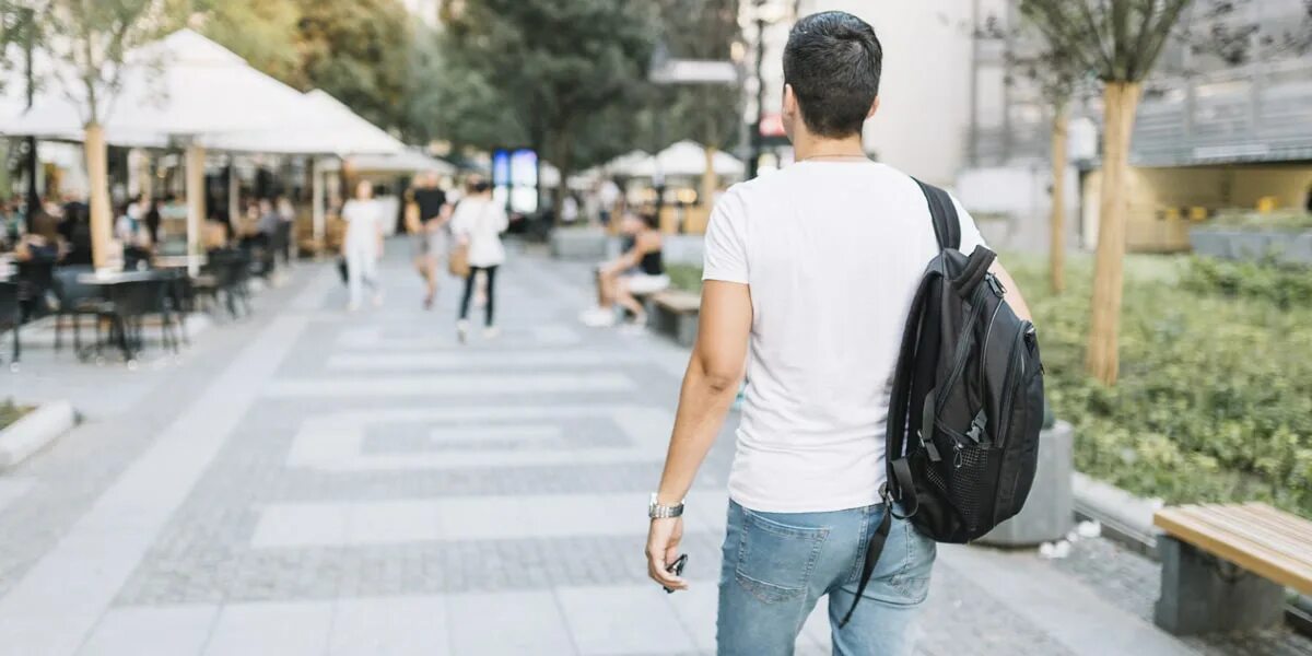 толпа со спины. парень идет по улице. люди на улице спиной. мужчина в капюшоне. рюкзак для подростка.