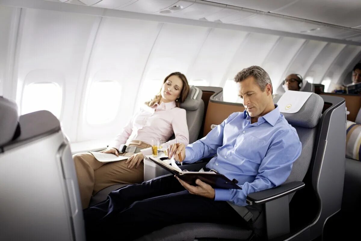 Первый урок полетов. Мужчина и женщина в самолете. Бизнес класс в самолете. Бизнесмен в самолете. Полет бизнес классом.